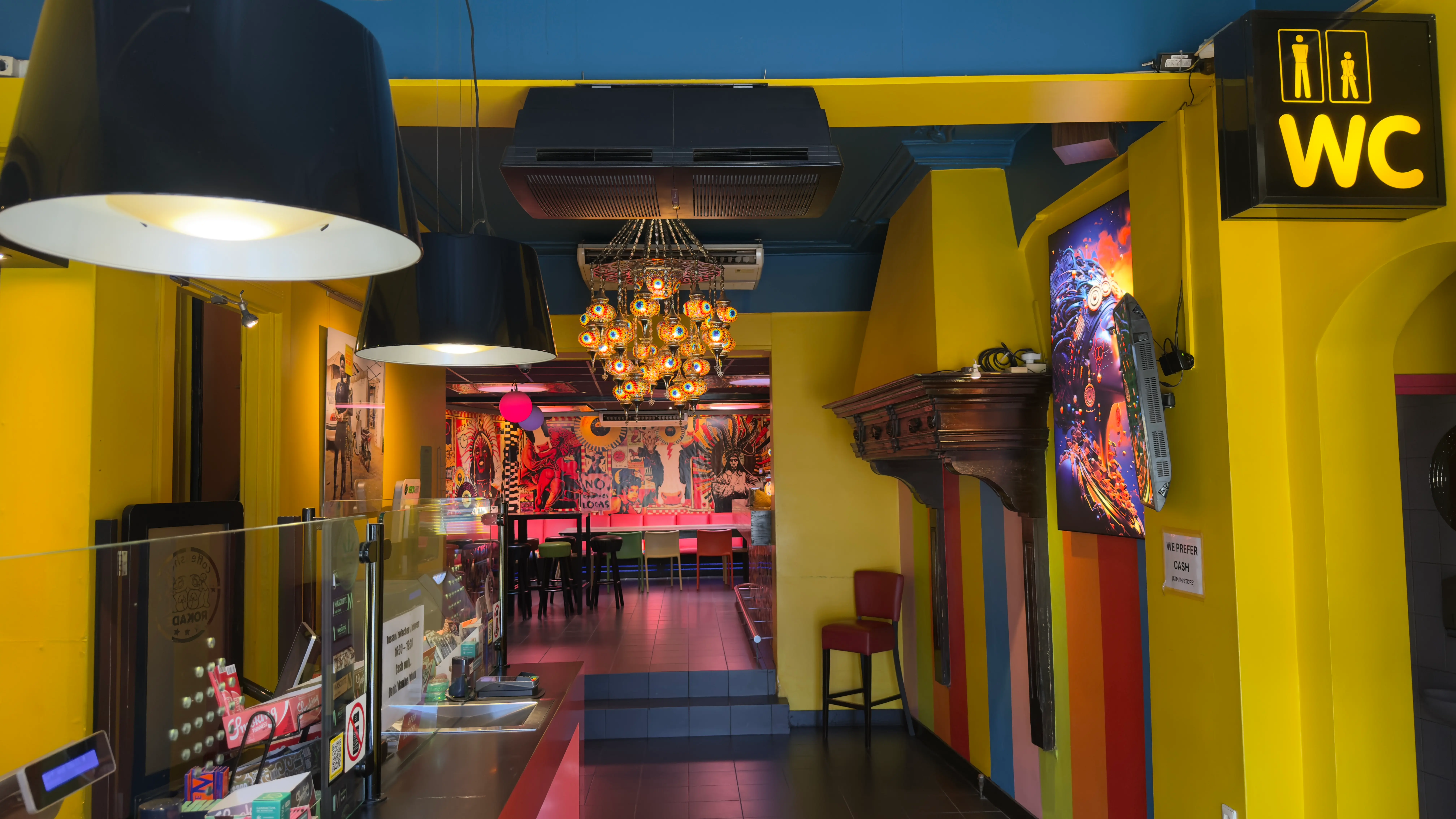 Coffeeshop Rokade — gang naar de loungeruimte met verlichte kunstpanelen