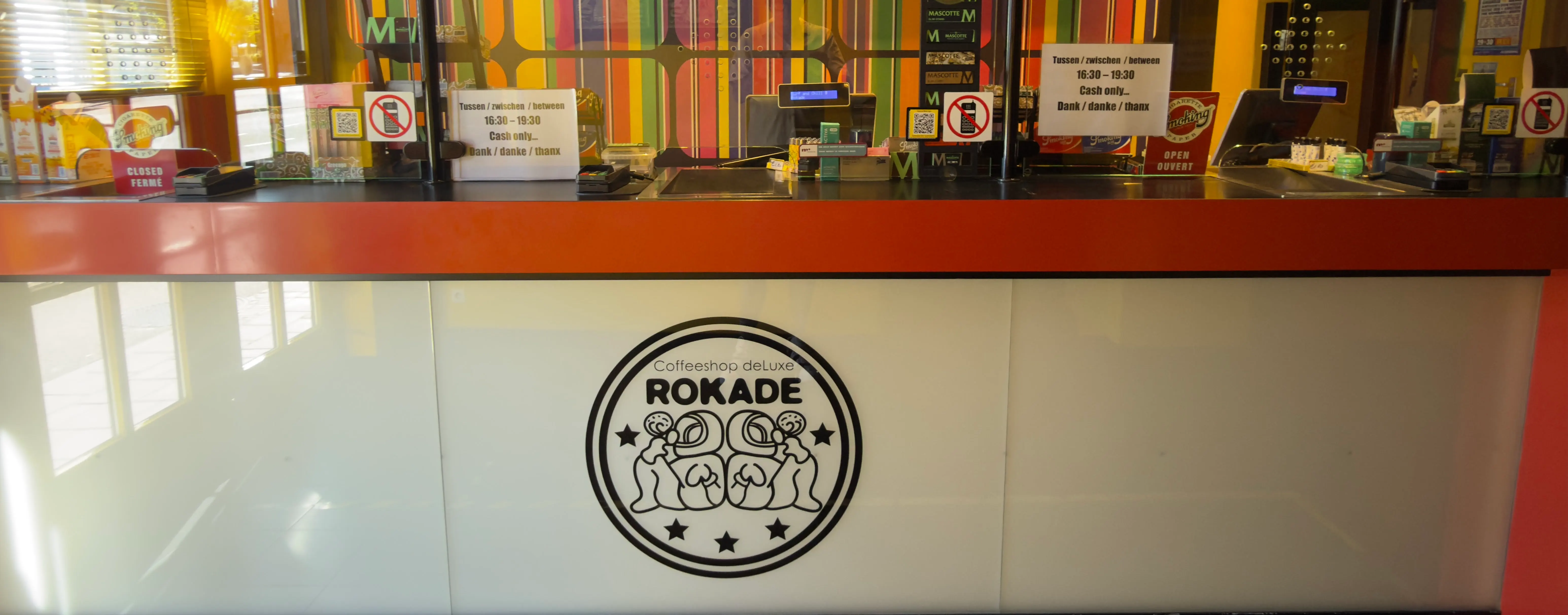 De toonbank van Coffeeshop Rokade met het Coffeeshop deLuxe-embleem